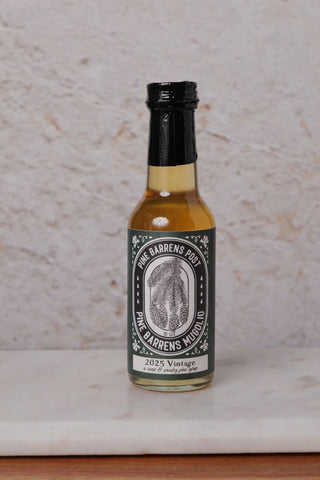 Bottle of Pinecone syrup on a textured surface